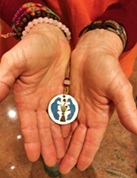 Hands holding a Camaldolese oblate medallion — click to open the Oblate Rule booklet